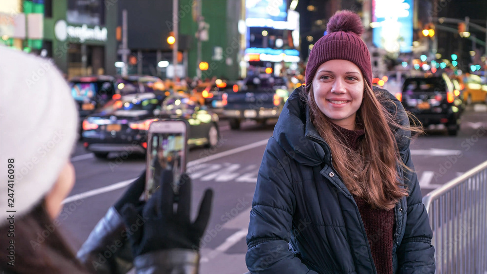 Two girls in New York take photos at Times Square Two girls in New York take photos at Times Square