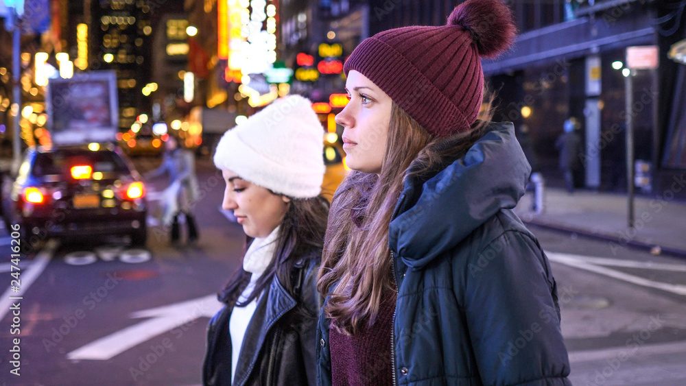 Fototapeta premium Walking on Times Square New York by night while doing a sightseeing trip to Manhattan