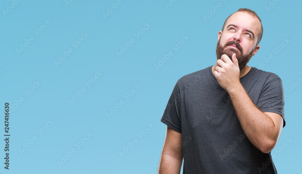 Young caucasian hipster man over isolated background with hand on chin thinking about question, pensive expression. Smiling with thoughtful face. Doubt concept. Young caucasian hipster man over isolated background with hand on chin thinking about question, pensive expression. Smiling with thoughtful face. Doubt concept.