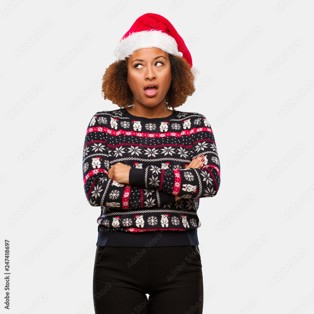 Young black woman in a trendy christmas sweater with print tired and bored