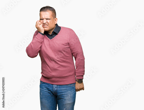 Middle age arab man over isolated background looking stressed and nervous with hands on mouth biting nails. Anxiety problem.