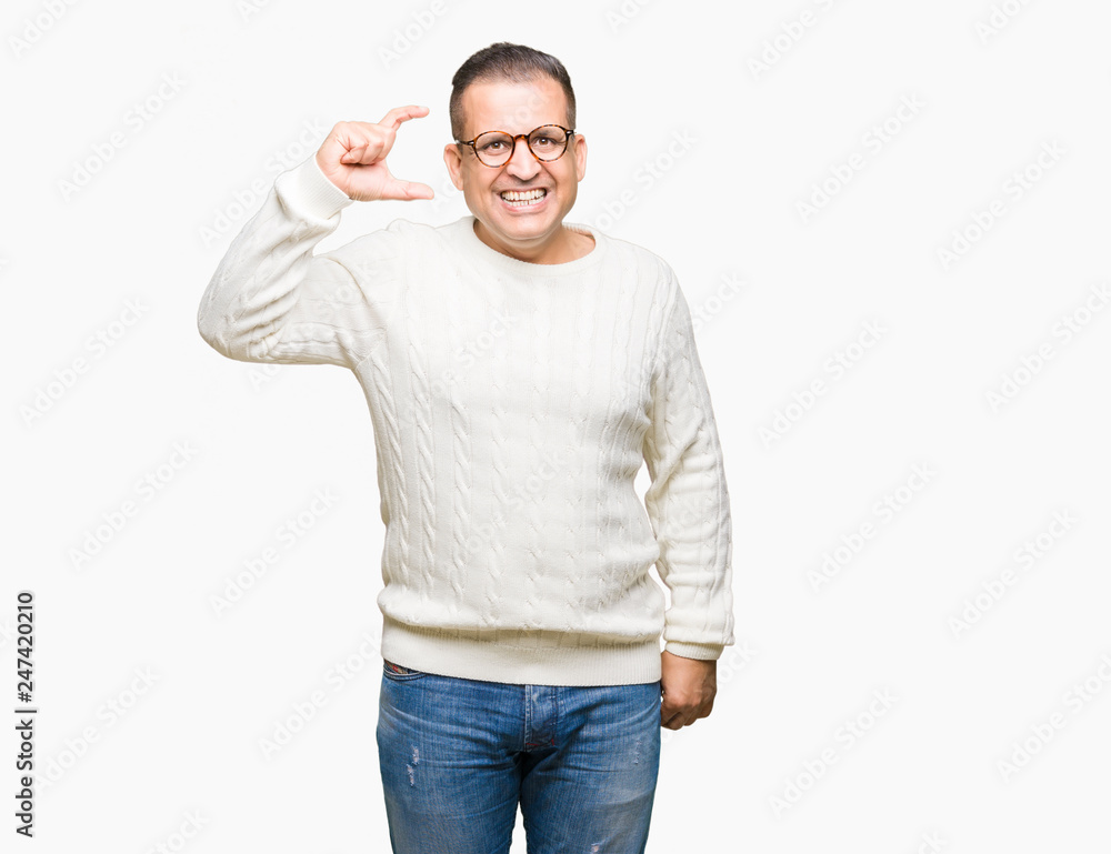 Middle age arab man wearing glasses over isolated background smiling and confident gesturing with hand doing size sign with fingers while looking and the camera. Measure concept. Middle age arab man wearing glasses over isolated background smiling and confident gesturing with hand doing size sign with fingers while looking and the camera. Measure concept.
