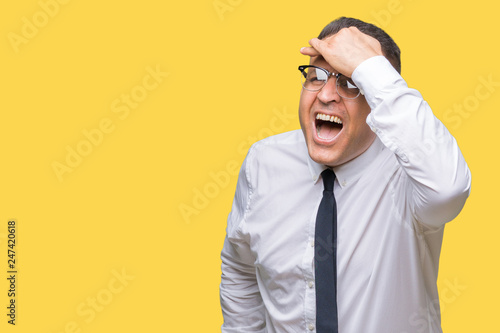 Middle age bussines arab man wearing glasses over isolated background very happy and smiling looking far away with hand over head. Searching concept. © Krakenimages.com