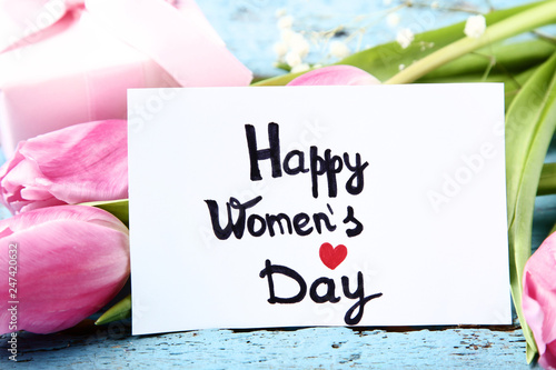 Fototapeta Naklejka Na Ścianę i Meble -  Text Happy Women's Day with pink tulip flowers on blue wooden table