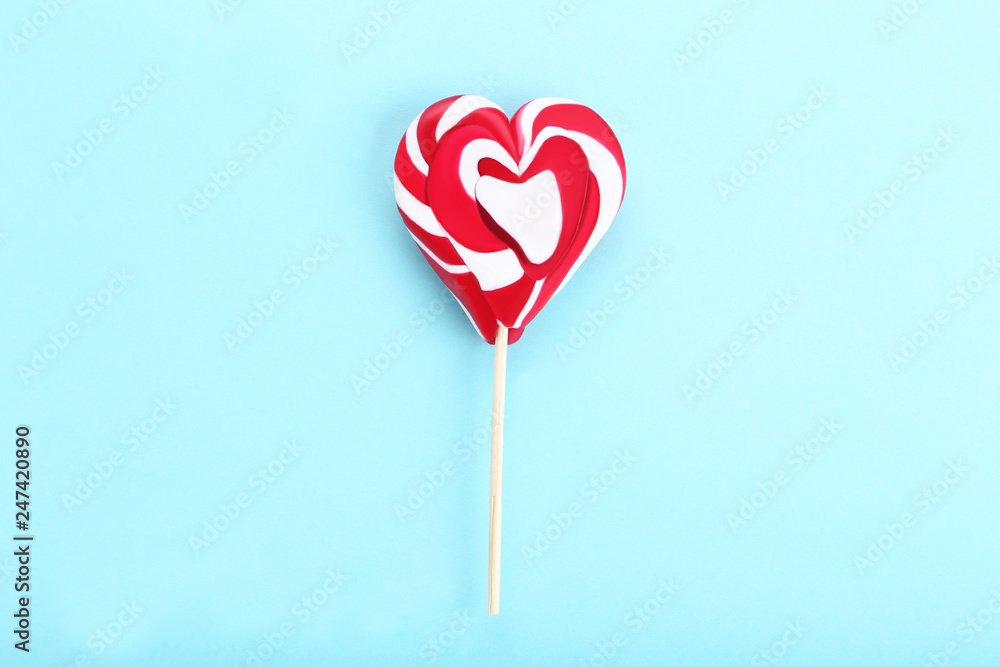 Heart shaped lollipop on blue background