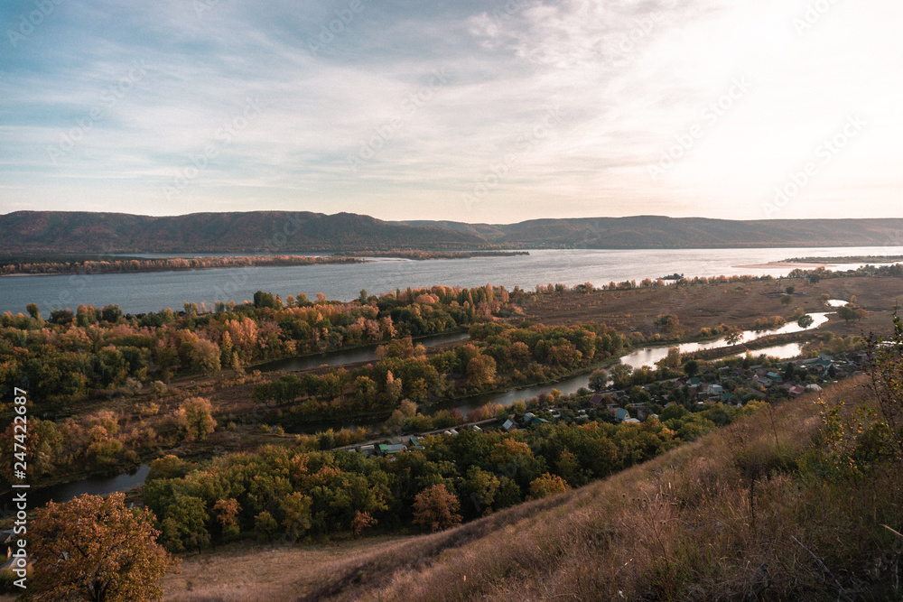 Overview from a height of the lake, river and village in autumn
