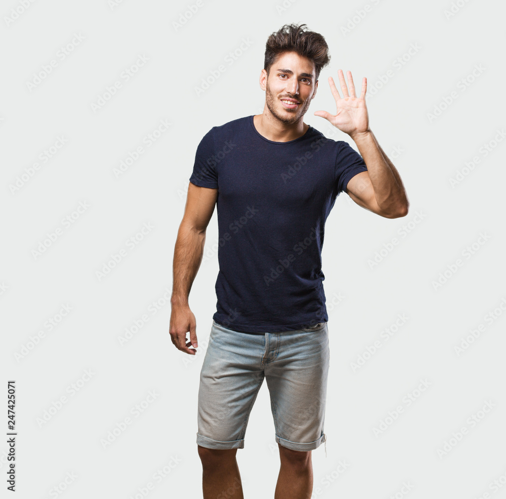 Young handsome man standing showing number five, symbol of counting, concept of mathematics, confident and cheerful Young handsome man standing showing number five, symbol of counting, concept of mathematics, confident and cheerful