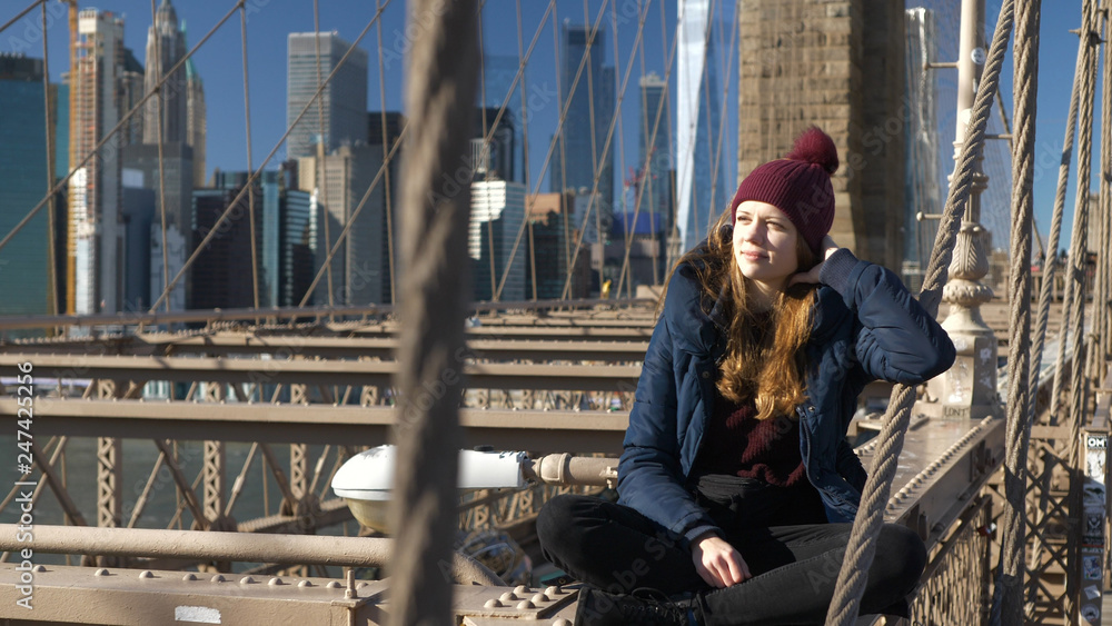 Beautiful girl on Brooklyn Bridge enjoys a sunny day while relaxing Beautiful girl on Brooklyn Bridge enjoys a sunny day while relaxing