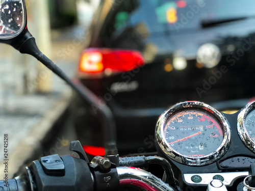 View of motorcycle panel stopped in traffic after rain