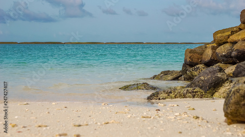 Felsen am Strand und Türkis wasser von Adaaran Select Meedhupparu auf Malediven im Indischer Ozean photo