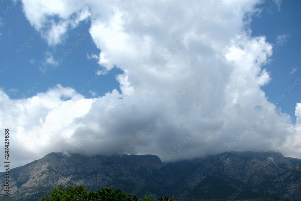 Mountains against the blue sky and clouds. Wild nature