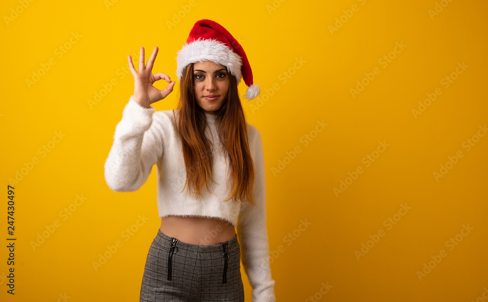 Young pretty woman holding gift cheerful and confident doing ok gesture Young pretty woman holding gift cheerful and confident doing ok gesture