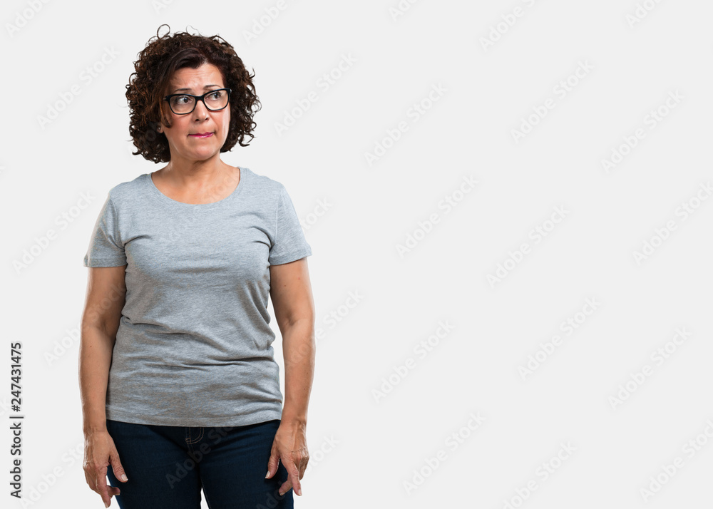 Fototapeta premium Middle aged woman doubting and confused, thinking of an idea or worried about something