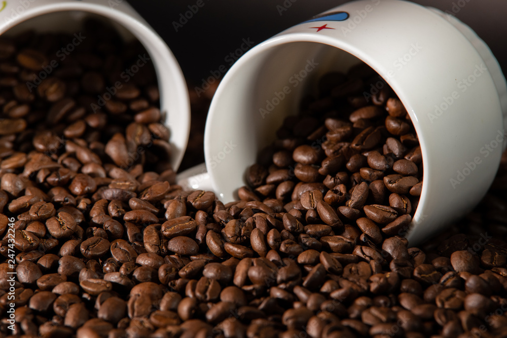 Fototapeta premium white cups with a pattern and grains of coffee on a black background