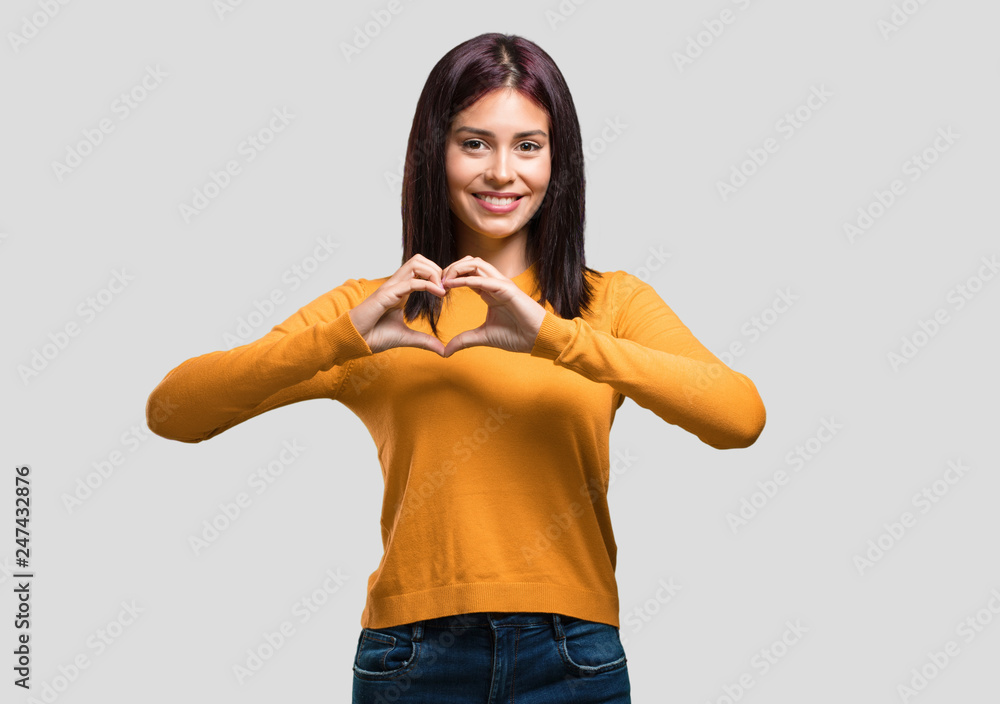 Young pretty woman making a heart with hands, expressing the concept of love and friendship, happy and smiling Young pretty woman making a heart with hands, expressing the concept of love and friendship, happy and smiling