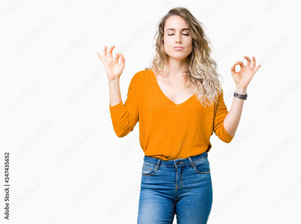 Beautiful young blonde woman over isolated background relax and smiling with eyes closed doing meditation gesture with fingers. Yoga concept. Beautiful young blonde woman over isolated background relax and smiling with eyes closed doing meditation gesture with fingers. Yoga concept.