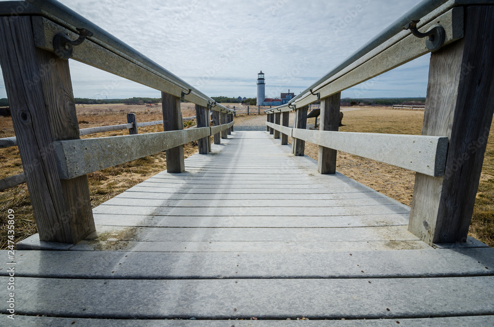 Unique view of the Highland Lighthouse on Cape Cod, through a wooden boardwalk on a spring day