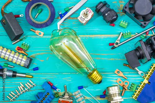 Tools and a set of components for use in electrical installations with an incandescent bulb in the center.