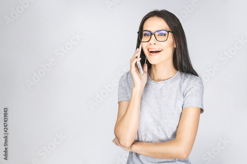 Laughing woman talking on the phone isolated on a white background.