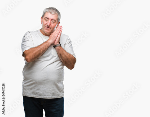 Handsome senior man over isolated background sleeping tired dreaming and posing with hands together while smiling with closed eyes.