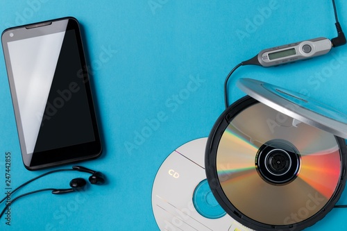 Fotografie personal cd player with remote control and modern smartphone on blue background
