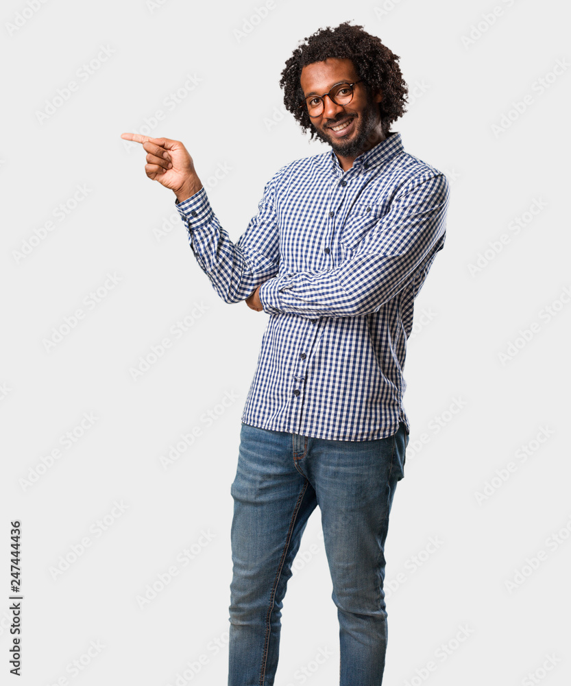 Handsome business african american man pointing to the side, smiling surprised presenting something, natural and casual Handsome business african american man pointing to the side, smiling surprised presenting something, natural and casual