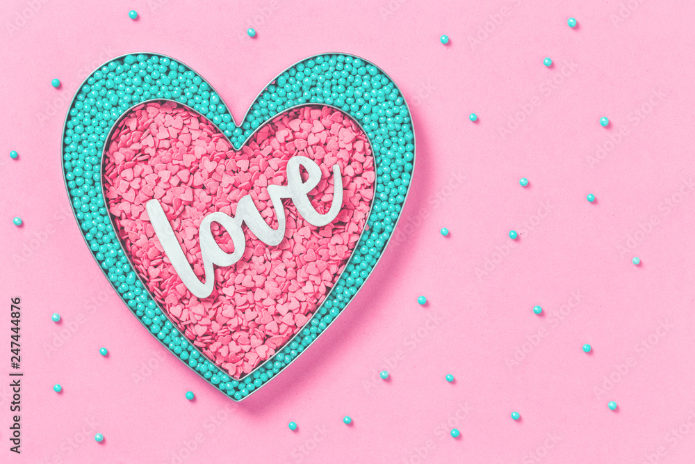 Pink and mint colors cake sprinkles sweets heart shape on pink background with copy space, flat lay. Love, Mother's and Valentines Day concept