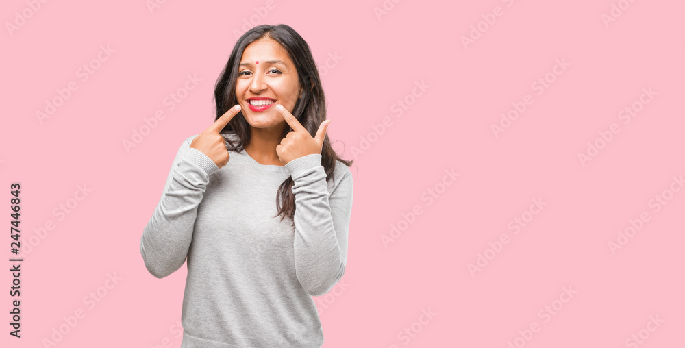 Portrait of young indian woman smiles, pointing mouth, concept of perfect teeth, white teeth, has a cheerful and jovial attitude Portrait of young indian woman smiles, pointing mouth, concept of perfect teeth, white teeth, has a cheerful and jovial attitude