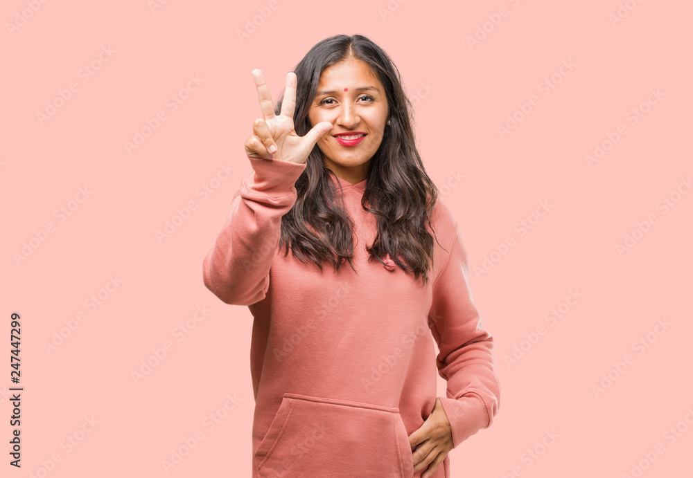 Portrait of fitness young indian woman showing number three, symbol of counting, concept of mathematics, confident and cheerful Portrait of fitness young indian woman showing number three, symbol of counting, concept of mathematics, confident and cheerful