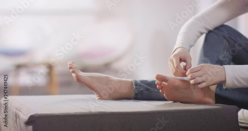 Young caucasian girl tending to her hurting foot