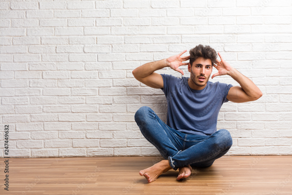 Young natural man sit on a wooden floor crazy and desperate, screaming out of control, funny lunatic expressing freedom and wild Young natural man sit on a wooden floor crazy and desperate, screaming out of control, funny lunatic expressing freedom and wild