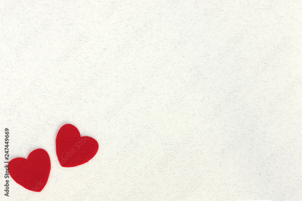 Fototapeta premium red felt hearts on white paper background with space for text