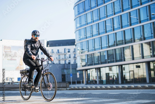 A male bicycle courier delivering packages in city. Copy space. photo
