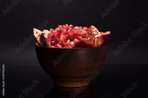 Peeled pomegranate fruit. Pomegranate fruit in a clay bowl.