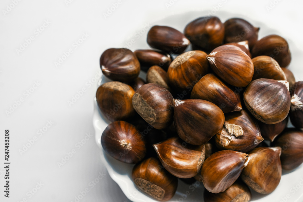 Chestnuts on a blank (white) background. Pile of fresh chestnuts ready to roast shot over white background Chestnuts on a blank (white) background. Pile of fresh chestnuts ready to roast shot over white background