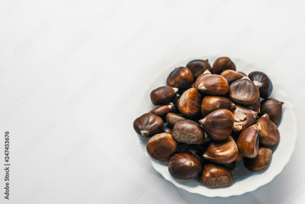 Chestnuts on a blank (white) background. Pile of fresh chestnuts ready to roast shot over white background Chestnuts on a blank (white) background. Pile of fresh chestnuts ready to roast shot over white background