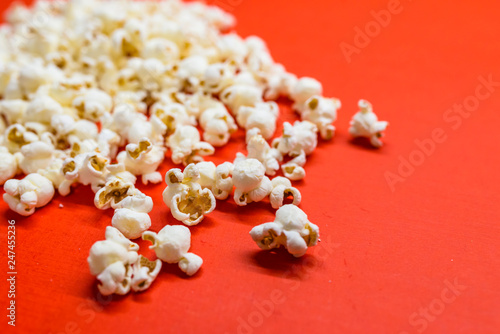 Tasty salted popcorn isolated on red background. Popcorn border isolated on red, clipping path included. Cinema, movies and entertainment concept.