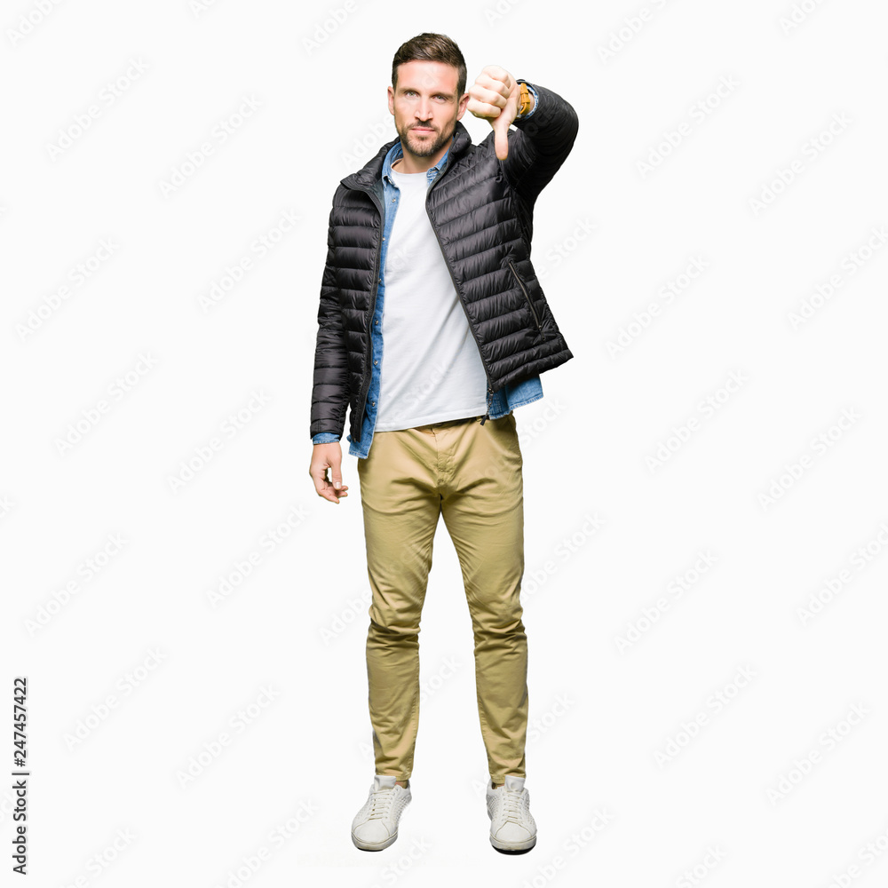 Handsome man wearing winter coat looking unhappy and angry showing rejection and negative with thumbs down gesture. Bad expression. Handsome man wearing winter coat looking unhappy and angry showing rejection and negative with thumbs down gesture. Bad expression.