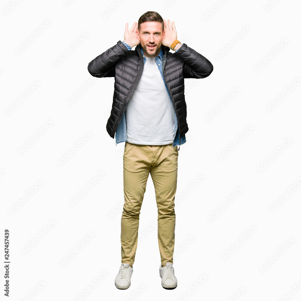 Handsome man wearing winter coat Trying to hear both hands on ear gesture, curious for gossip. Hearing problem, deaf Handsome man wearing winter coat Trying to hear both hands on ear gesture, curious for gossip. Hearing problem, deaf