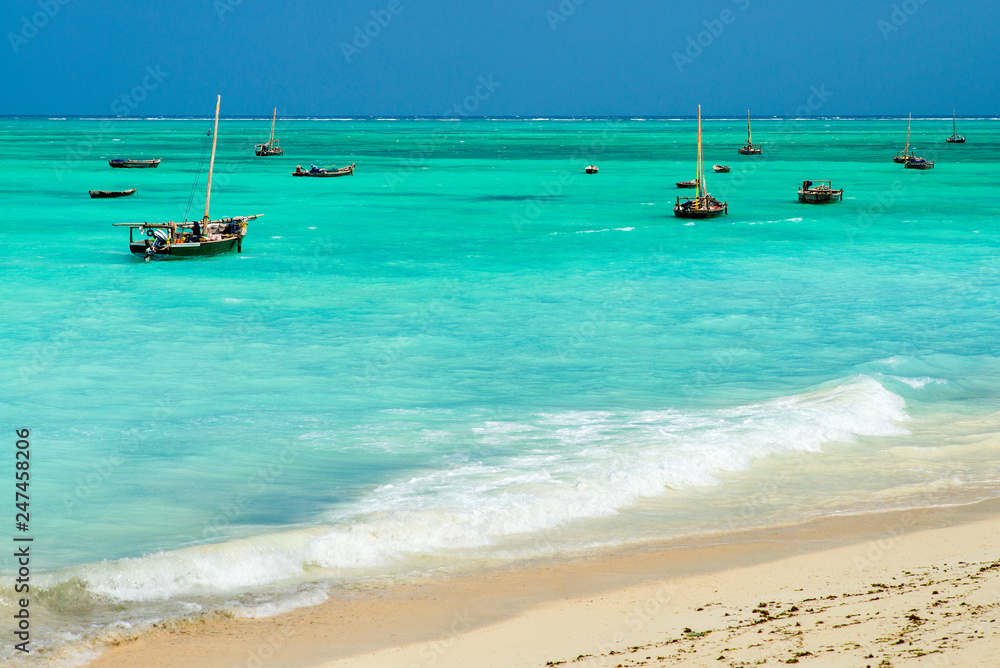 group of fishing boats in emerald lagoon at sea in Zanzibar in Tanzania group of fishing boats in emerald lagoon at sea in Zanzibar in Tanzania