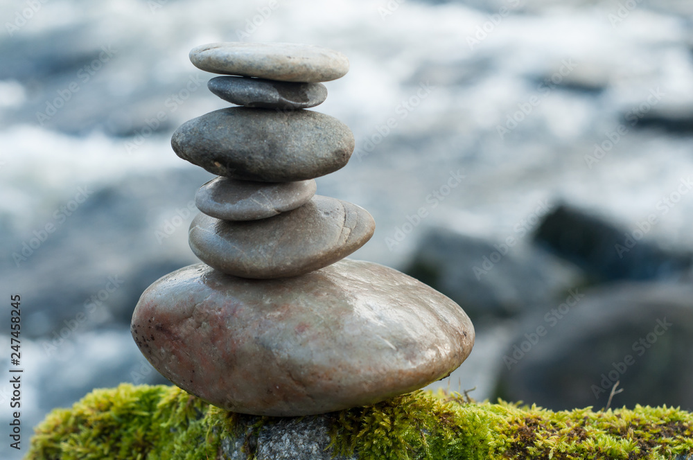 Closeup of stone balance on rock in border river Closeup of stone balance on rock in border river