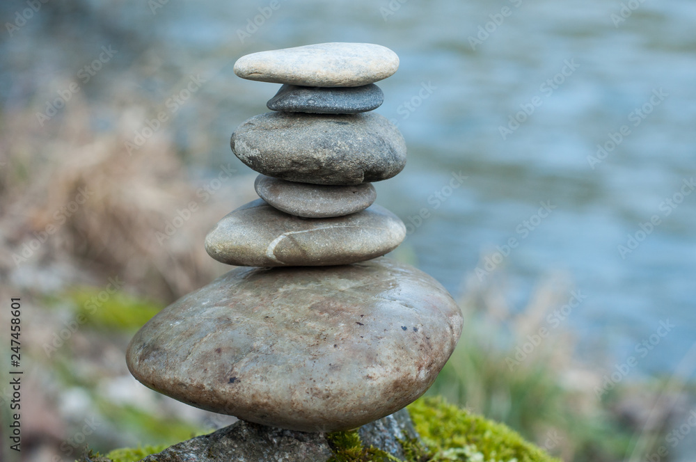 Closeup of stone balance on rock in border river Closeup of stone balance on rock in border river