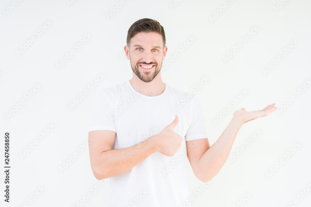 Young handsome man wearing casual white t-shirt over isolated background Showing palm hand and doing ok gesture with thumbs up, smiling happy and cheerful Young handsome man wearing casual white t-shirt over isolated background Showing palm hand and doing ok gesture with thumbs up, smiling happy and cheerful