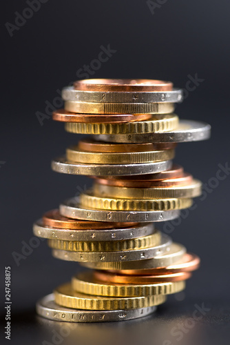 Coins stacked on each other in different positions on a black background