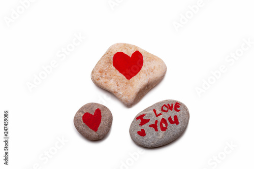 Three pebbles, two with painted red hearts and wone with I LOVE YOU painted on it