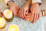 close-up of hands couple in love on the table with candles. on t