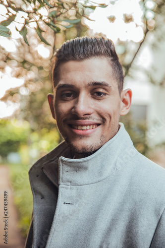 Face of brunette man smiling at green park in Barcelona