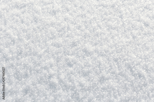 Fresh fluffy snow texture in the sun. Winter background with top view closeup
