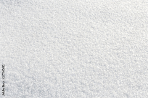 Fresh fluffy snow texture in the sun. Winter background with high angle view