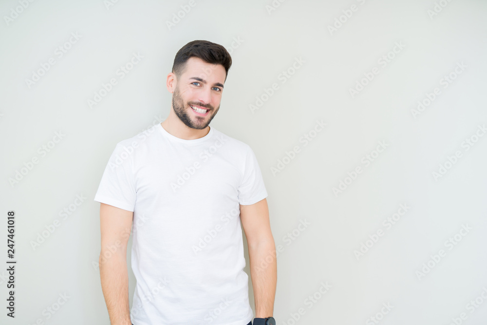 Young handsome man wearing casual white t-shirt over isolated background looking away to side with smile on face, natural expression. Laughing confident. Young handsome man wearing casual white t-shirt over isolated background looking away to side with smile on face, natural expression. Laughing confident.